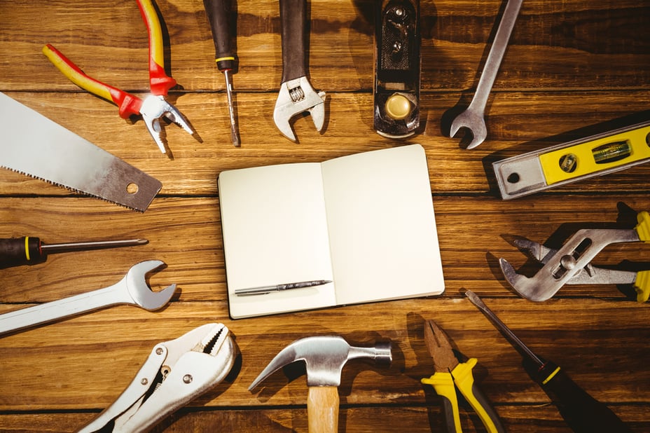 Notebook and pen against tools on desk-1 Notebook and pen against tools on desk-1