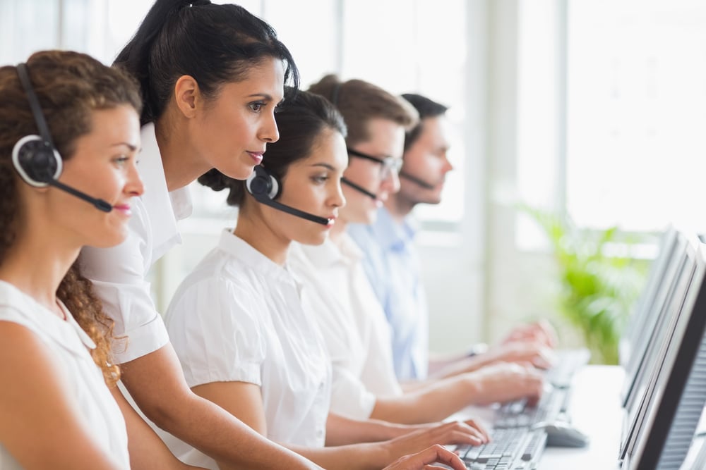 Side view of female manager assisting her staffs in a call center Side view of female manager assisting her staffs in a call center