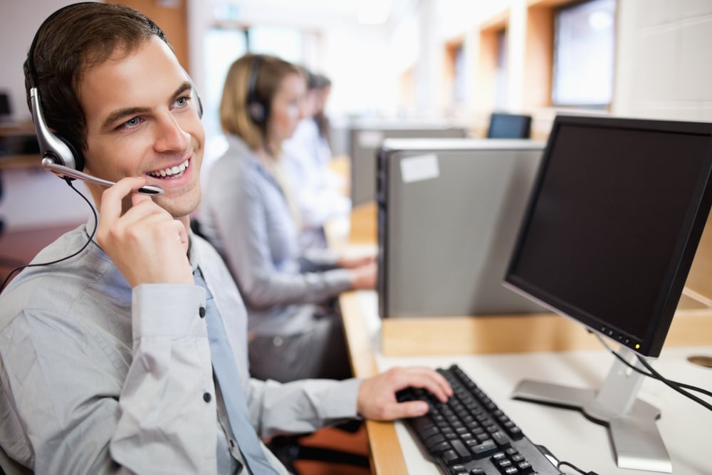 Smiling assistant using a headset in a call center-1 Smiling assistant using a headset in a call center-1