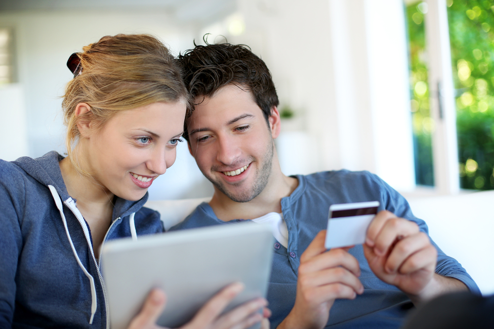 Happy young couple doing shopping on internet Happy young couple doing shopping on internet